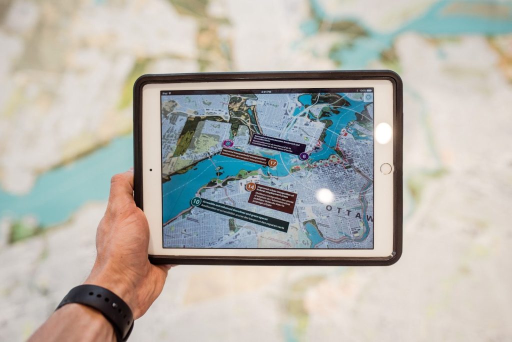 Hand holding a tablet displaying a map view of a city